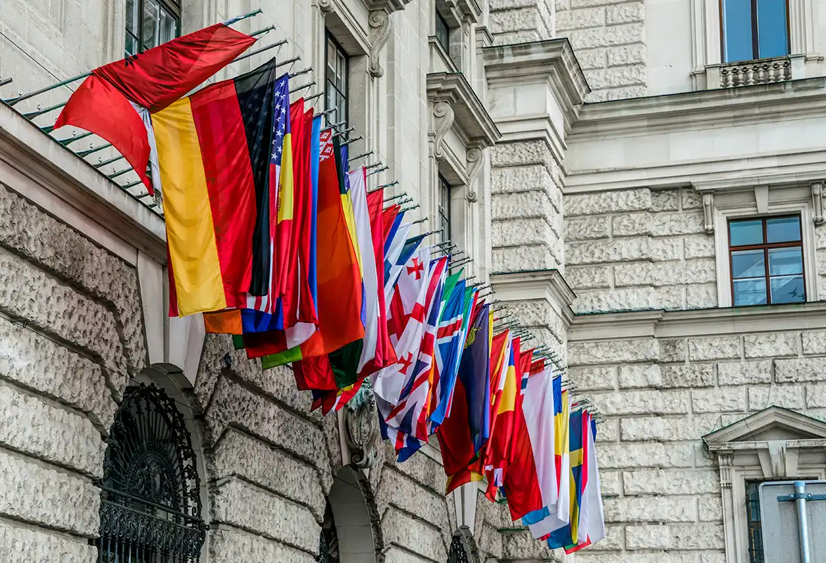 Rad av nationsflaggor på fasaden till en diplomatisk byggnad, symbolen för de internationella beskickningar varje utrikesförvaltning har runt om i världen.